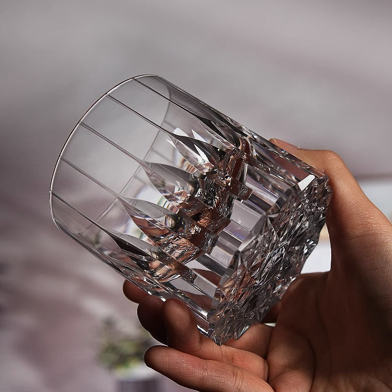 Starry Crystal Glass held in a hand, showing its vertical facets and cut base